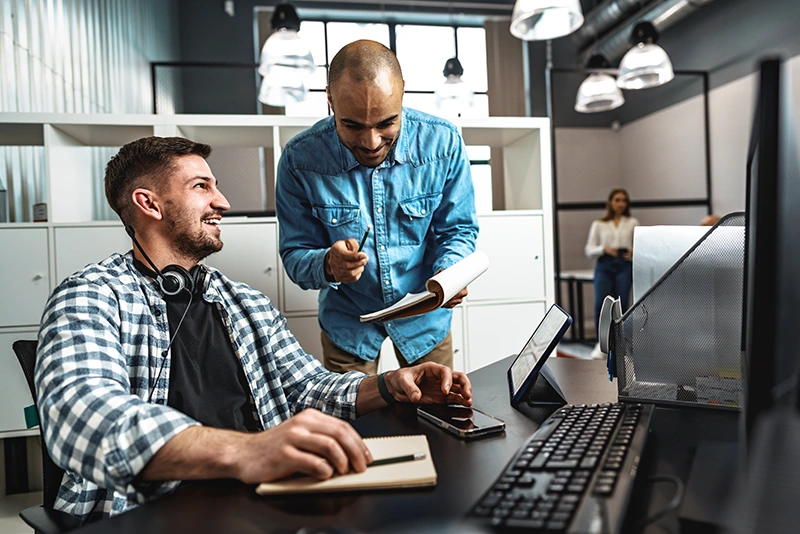 IT professionals collaborating at a workstation in a modern office